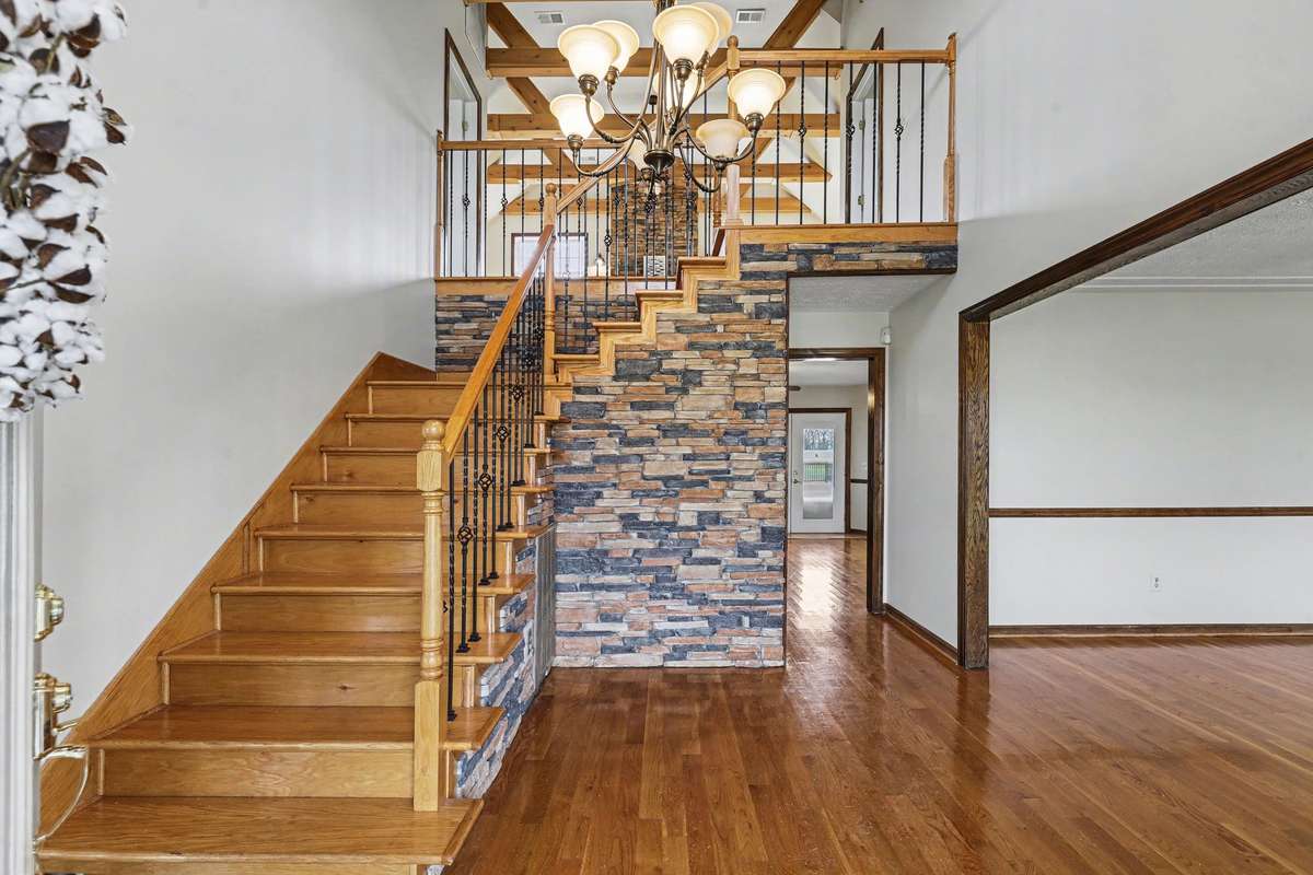 Dramatic Entry With Beautiful Staircase And Hardwood Floors