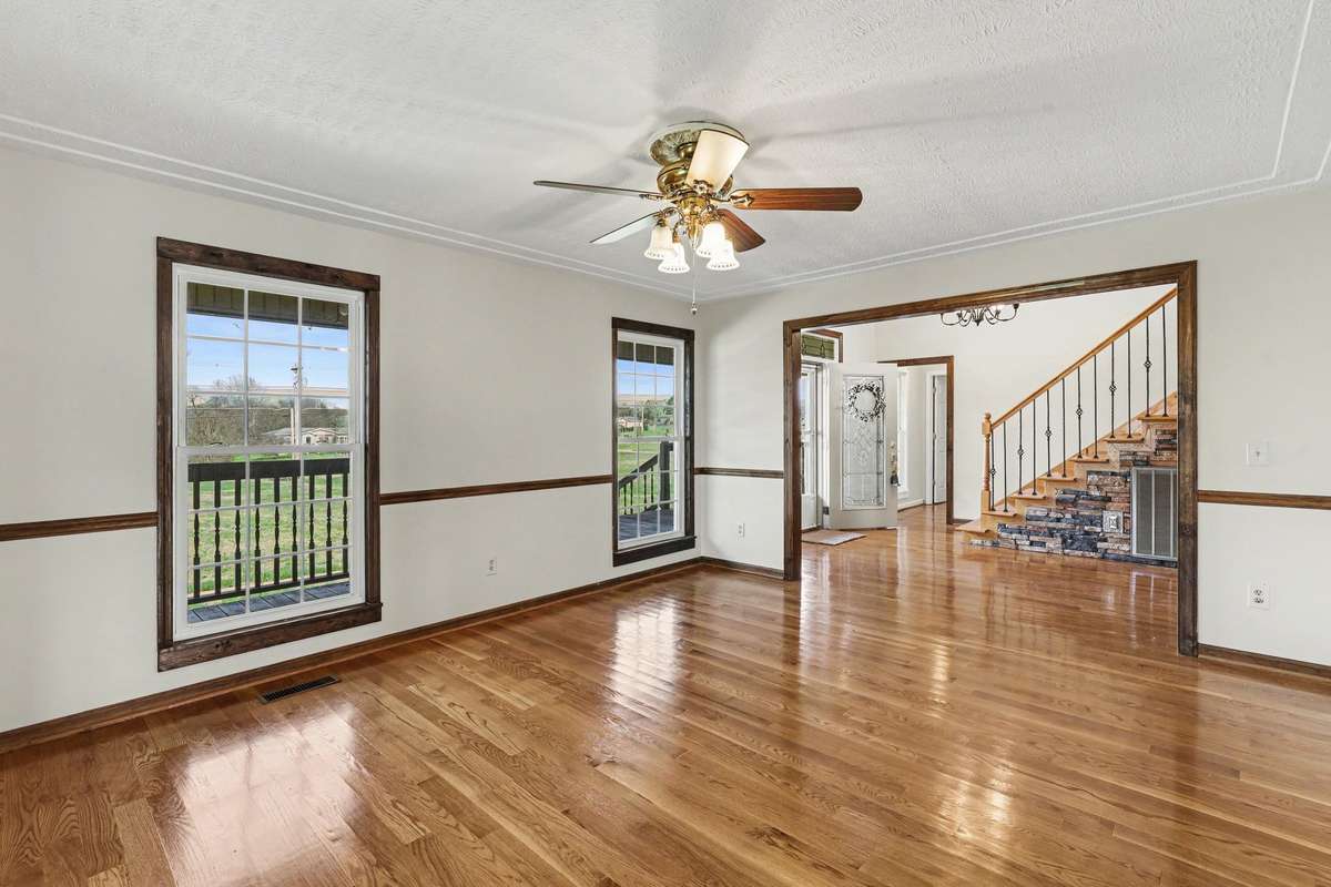 Another View of The Formal Dining Room With Views Into The Grand Entryway Featuring Beautiful Hardwood Floors