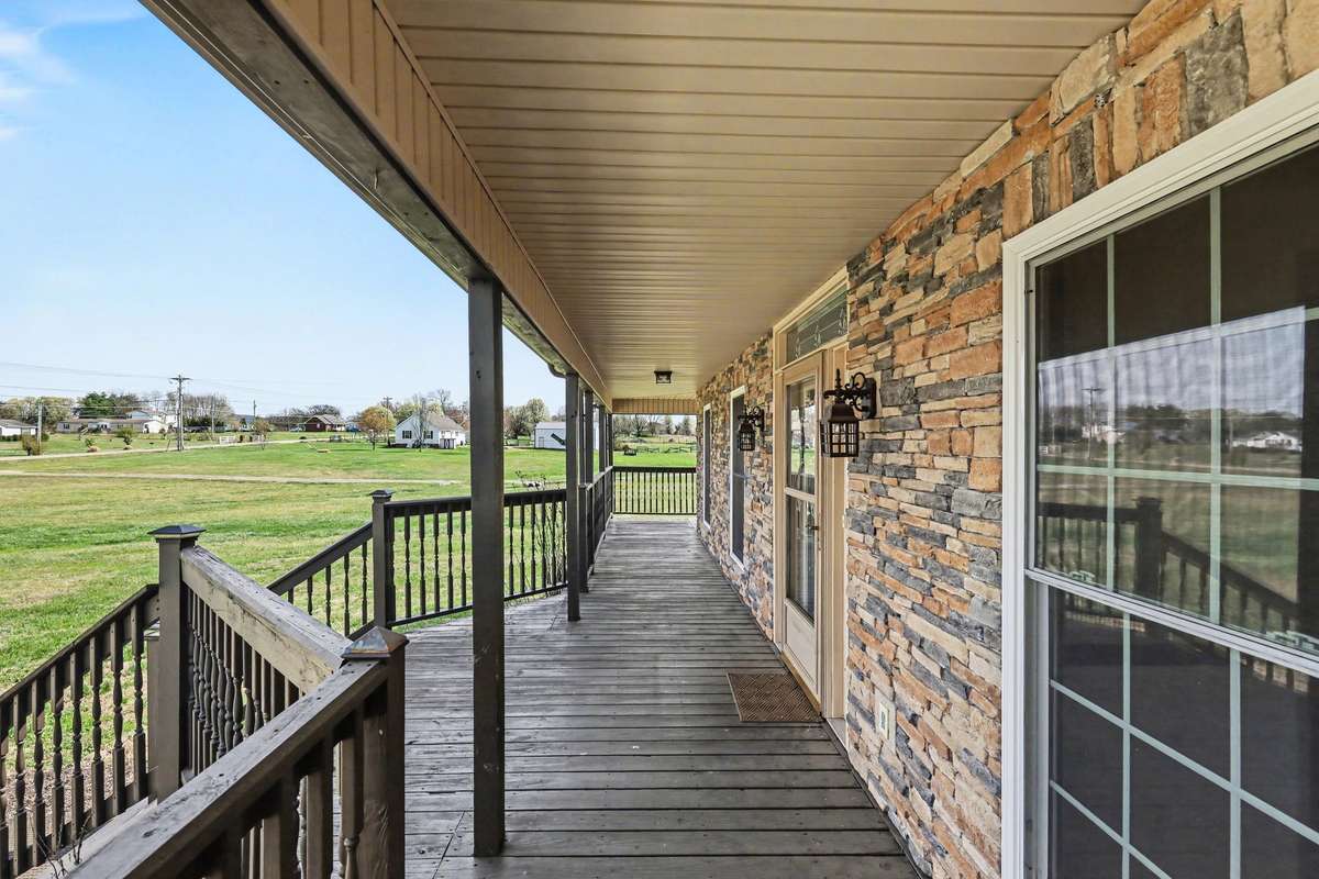 A Long Covered Wraparound Porch Made For Relaxing with Peaceful Country Views