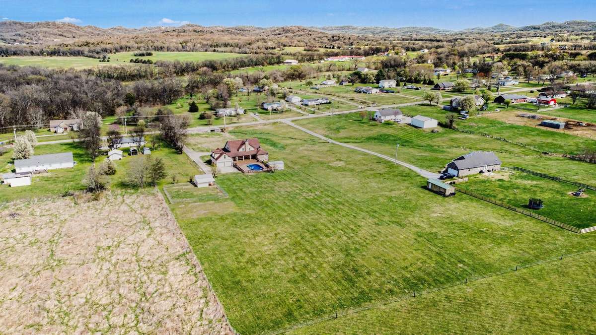 The property features a private pool, multiple outbuildings, and plenty of room for hobbies, equipment, or livestock. The large, level acreage provides endless opportunities