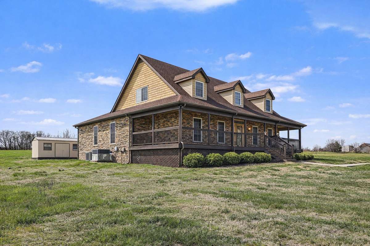 The stunning wraparound porch welcomes you to this beautifully crafted home, set against wide-open views and expansive green space. With its blend of stonework and warm architectural details, this property offers the perfect balance of privacy, space
