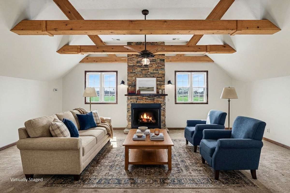 A Stunning Den located upstairs separating the bedrooms, Featuring Exposed Wood Beams And A Third Cozy Fireplace — Perfect For A Man Cave, Game Room, Or Relaxing Retreat *Virtually Staged