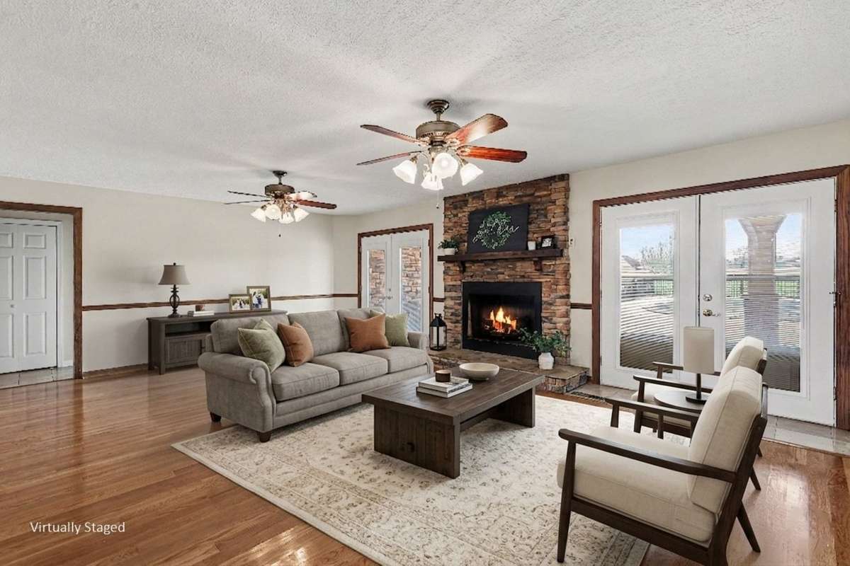 Gather And Relax Around The Beautiful Stone Fireplace With Easy Access To The Enormous Deck And Swimming Pool Through Doors On Either Side *Virtually Staged