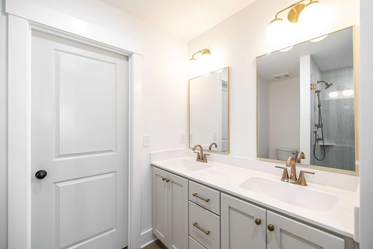 Double vanity in Primary bath has custom cabinetry, champagne bronze faucets & designer finishes~
