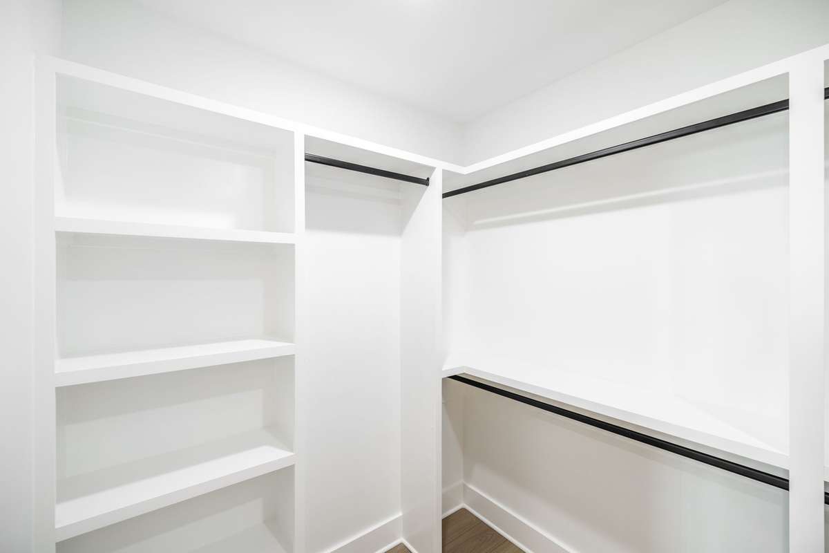 Primary walk in closet is large with wood shelving~