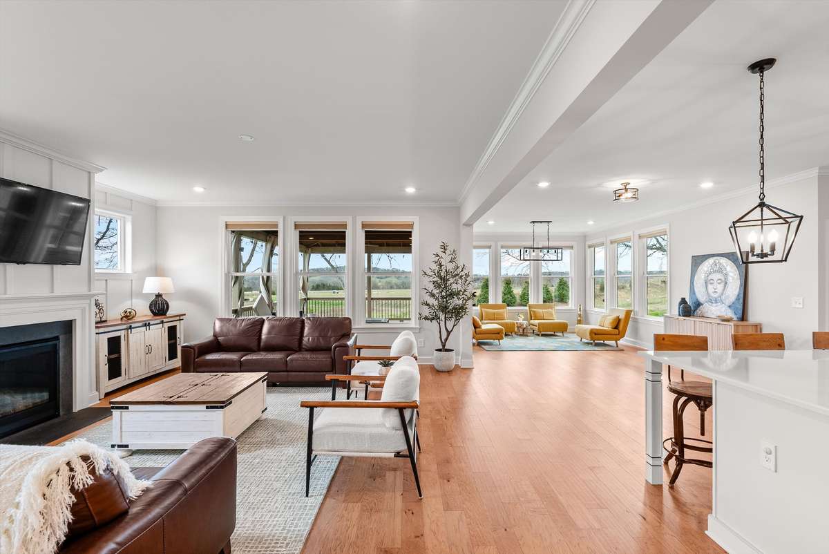 Bright, open-concept living with warm hardwoods, expansive windows, and seamless flow from living room to kitchen—perfect for everyday living and entertaining.