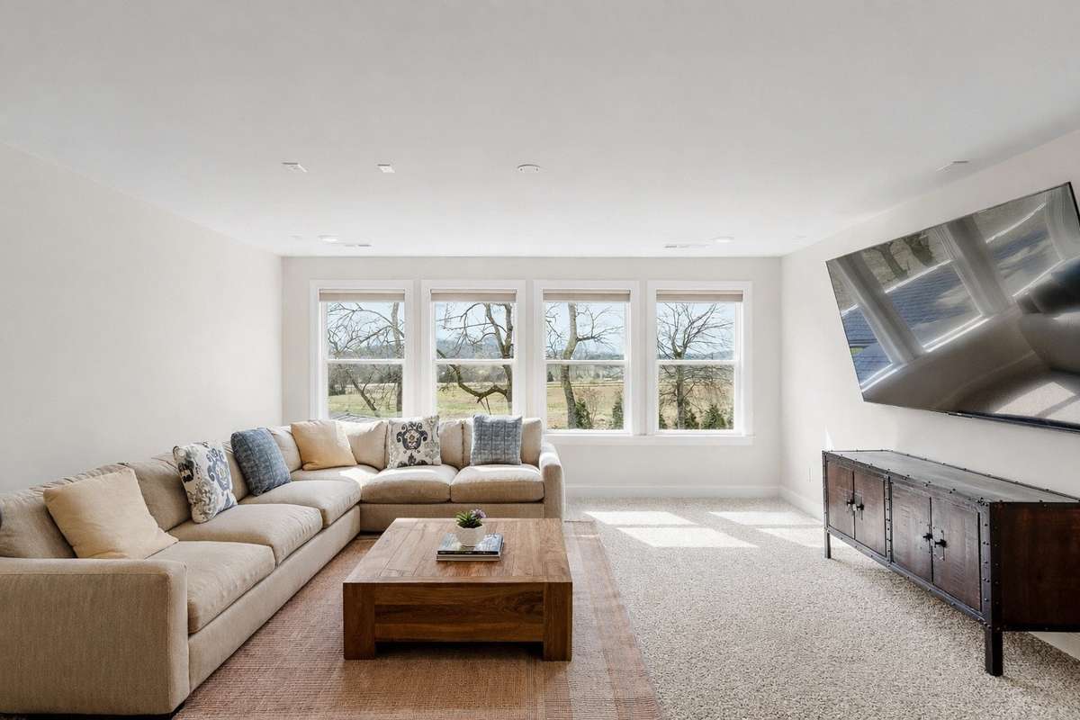 Generous bonus living space with oversized windows, plush carpeting, and flexible layout—perfect for a media room, playroom, or relaxed family retreat.