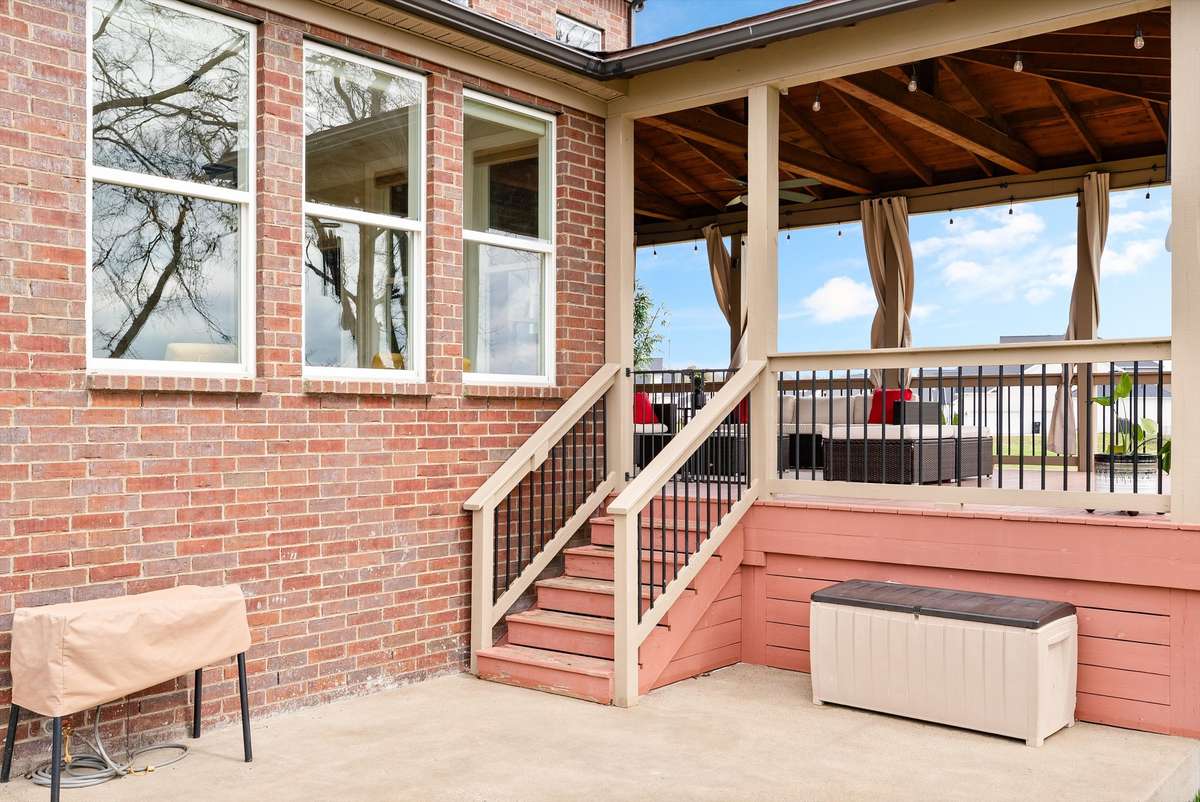Elevated deck access leading to a beautifully finished covered outdoor living space, seamlessly extending the home’s entertaining and relaxation areas.