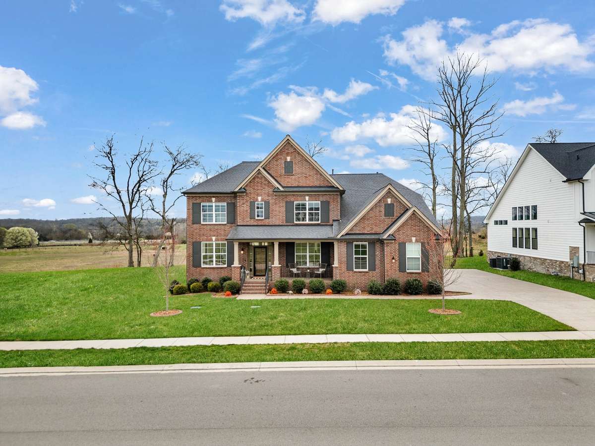 A final look at the home’s charming curb appeal, showcasing its classic brick exterior, spacious setting, and picturesque surroundings.