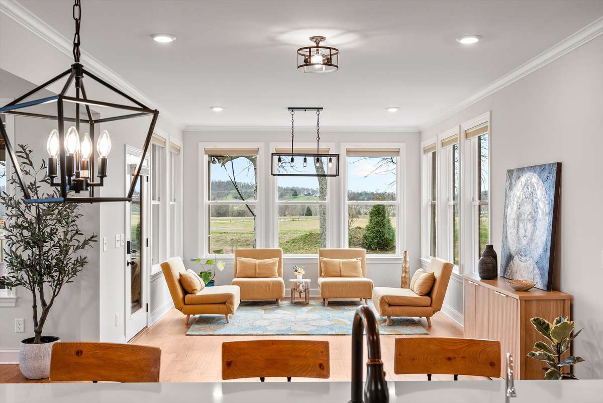 Sun-drenched sitting area framed by walls of windows, offering peaceful views and a perfect space to relax, unwind, or entertain.