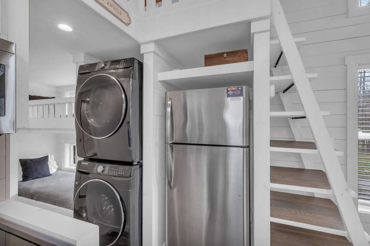 Stainless steel refrigerator and full size washer and dryer neatly tucked away in this thoughtfully laid out home