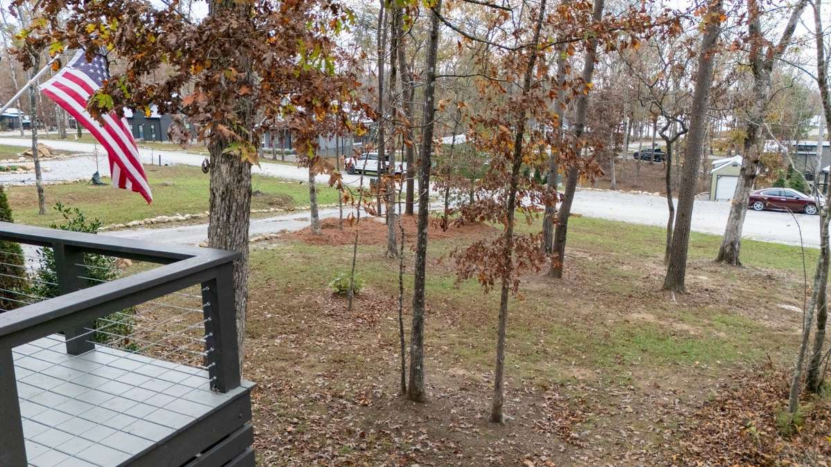 View from the side of the house showing the deck sitting on the highest point of the lot and overlooking the lake in the horizon