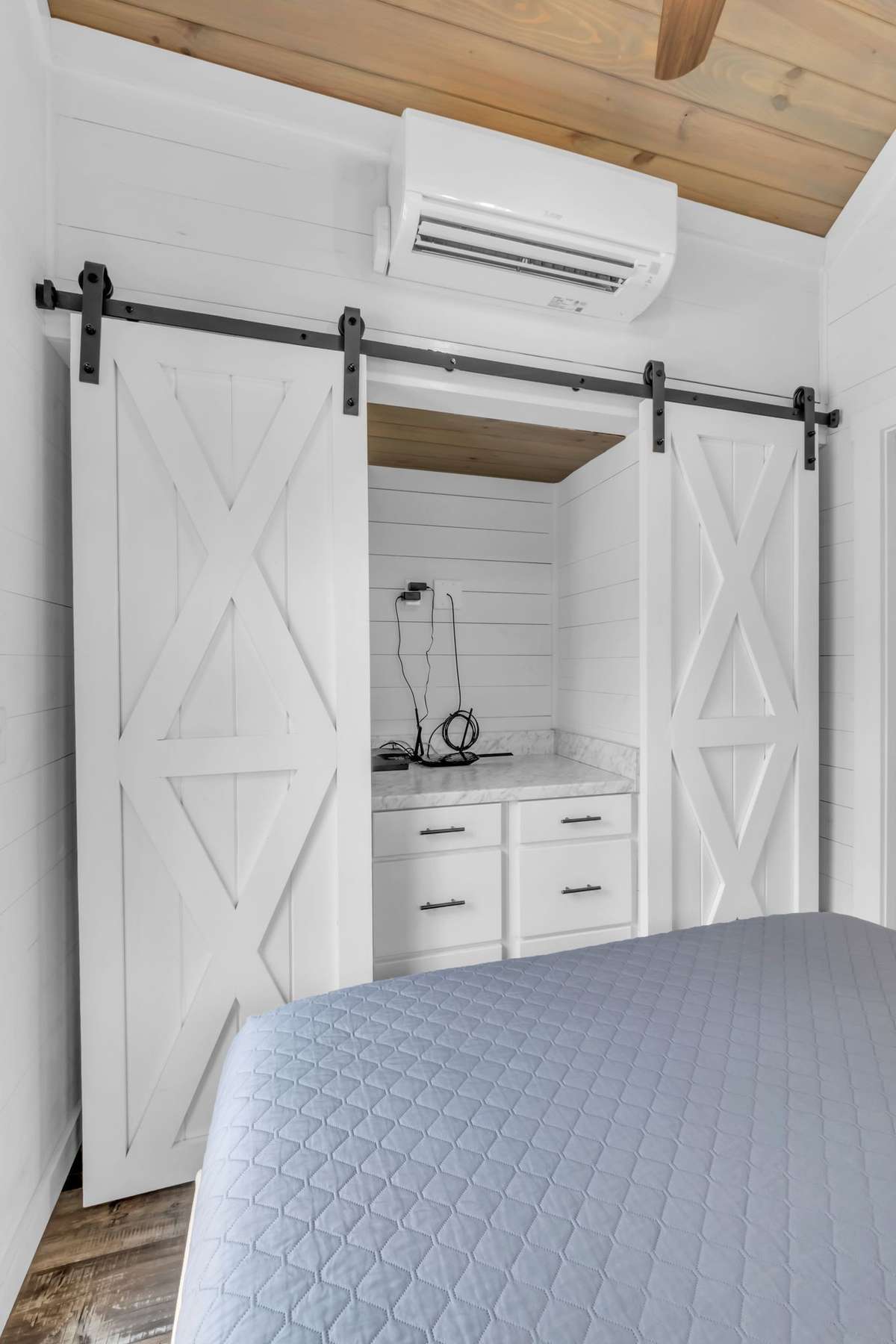 Two closets behind the barn doors and a dresser in the middle with room to hang a mirror or a TV