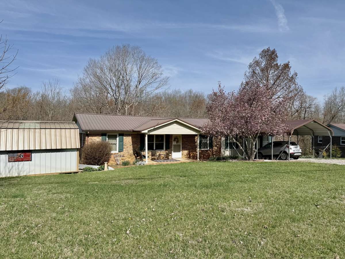 View of home, storage building, and carport.