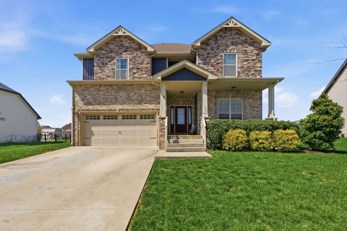 Beautiful brick and stone exterior with covered front porch, 2-car garage, and well-maintained landscaping in a desirable neighborhood.