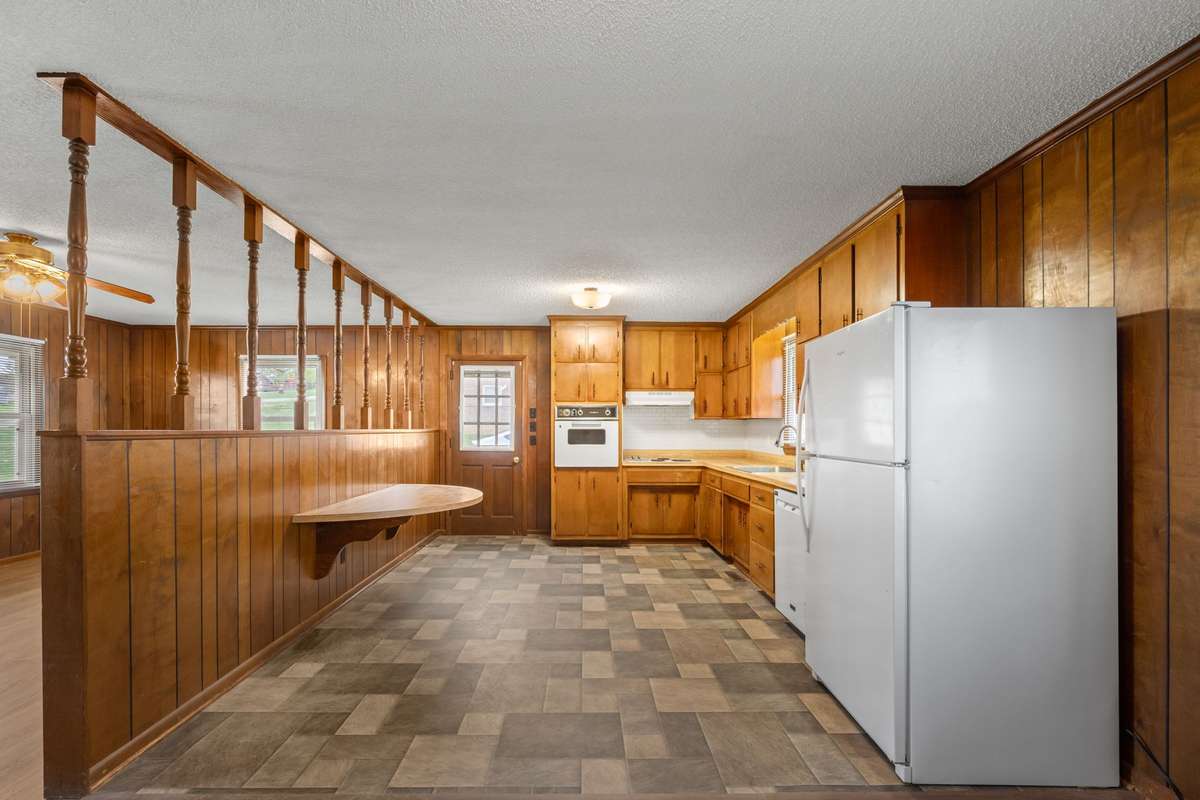 Kitchen with built-in breakfast bar, wood cabinetry and new refrigerator/dishwasher!