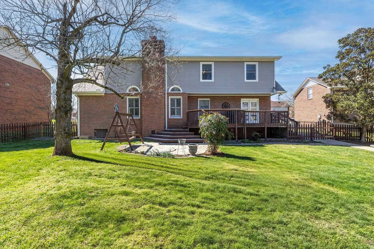 View of rear of home showing large backyard, all fenced.