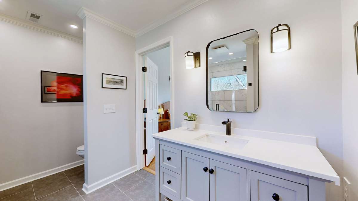 New vanity with plenty of storage and toilet area is tucked away behind a wall.