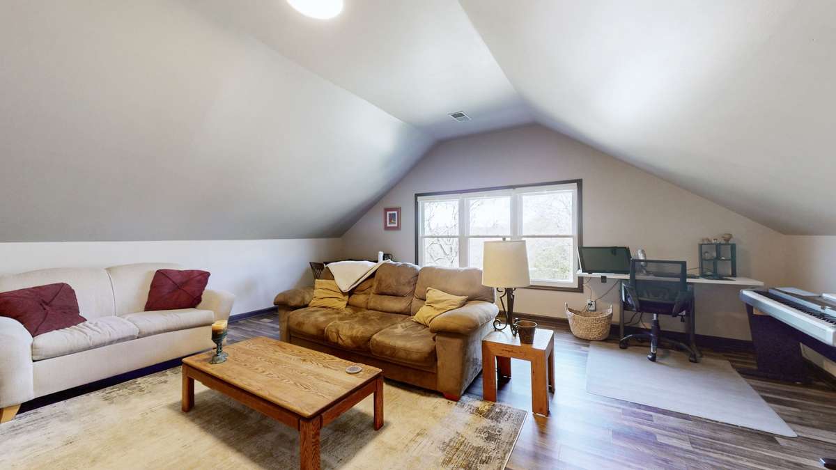 Large bonus room over the garage with easy access off the kitchen. The triple window looks out over the backyard.