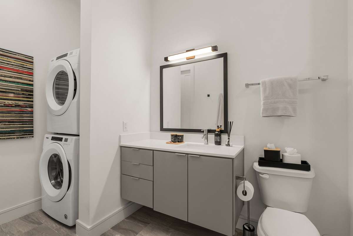 Spacious bathroom with large vanity, washer/dryer across from closet
