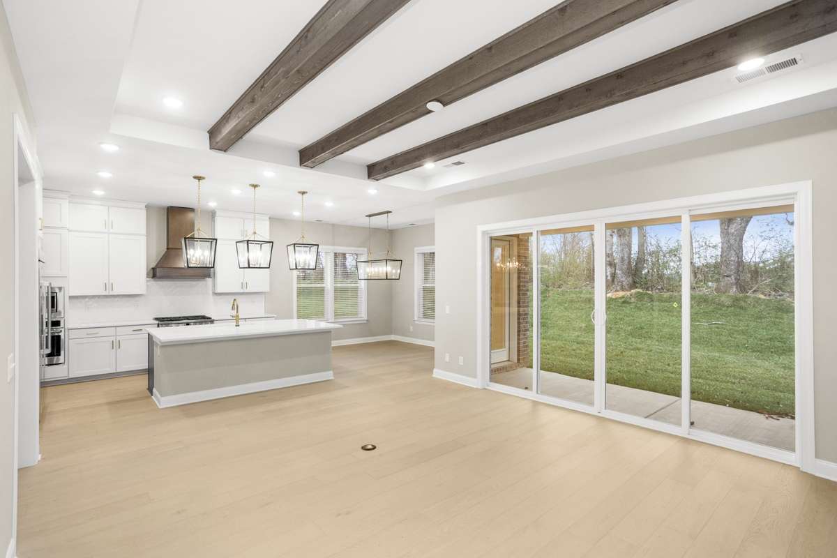 Another view of the family room into the kitchen and eating area, with a view of the back yard and patio