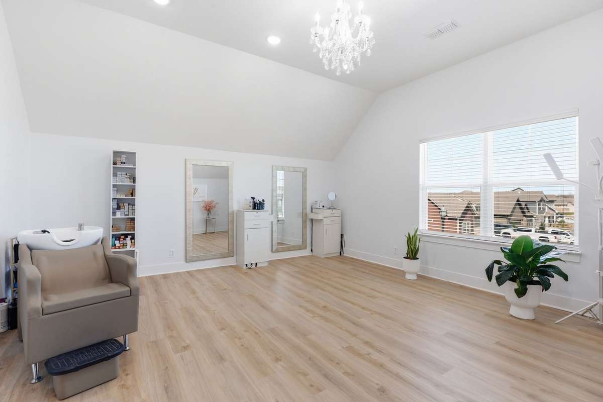 Spacious bonus room w/ vaulted ceilings and laminate flooring, offering endless possibilities. Filled with natural light from large windows and accented by a stylish chandelier, this versatile area provides provides plenty of room.