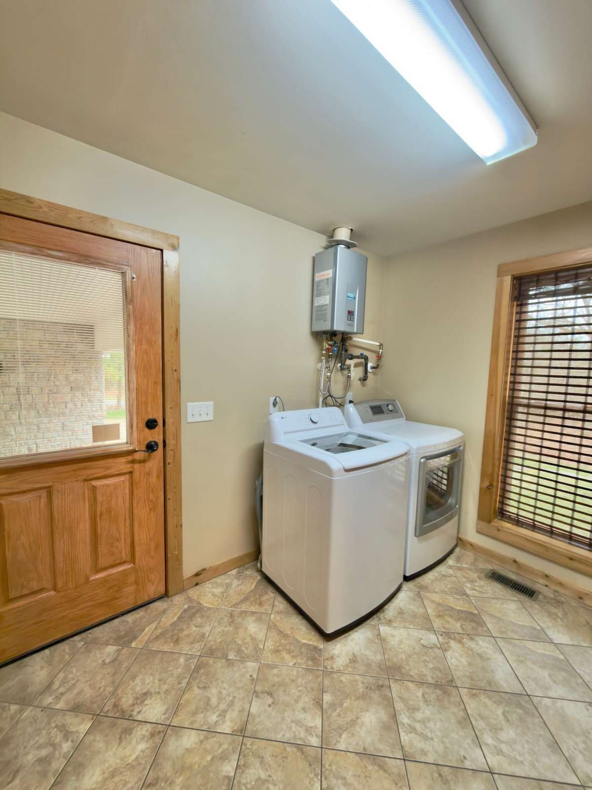 Utility room with whole house tankless water heater.