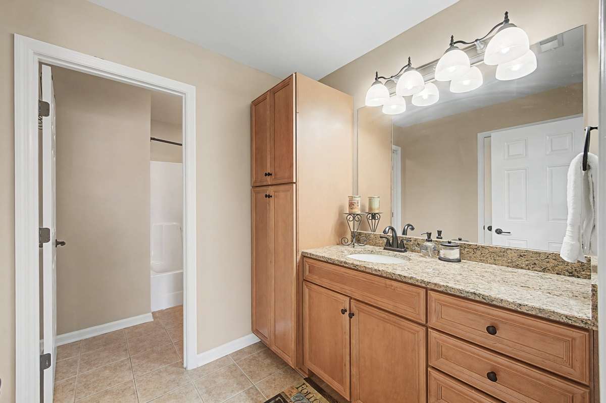 Bedrooms #2 & #3 share this large bathroom.  Large linen cabinet provides ample space.  Granite countertop, upgraded faucet and fixtures, tile floor for fresh look in this bathroom.   Tub/shower combo and toilet separated for shared use.