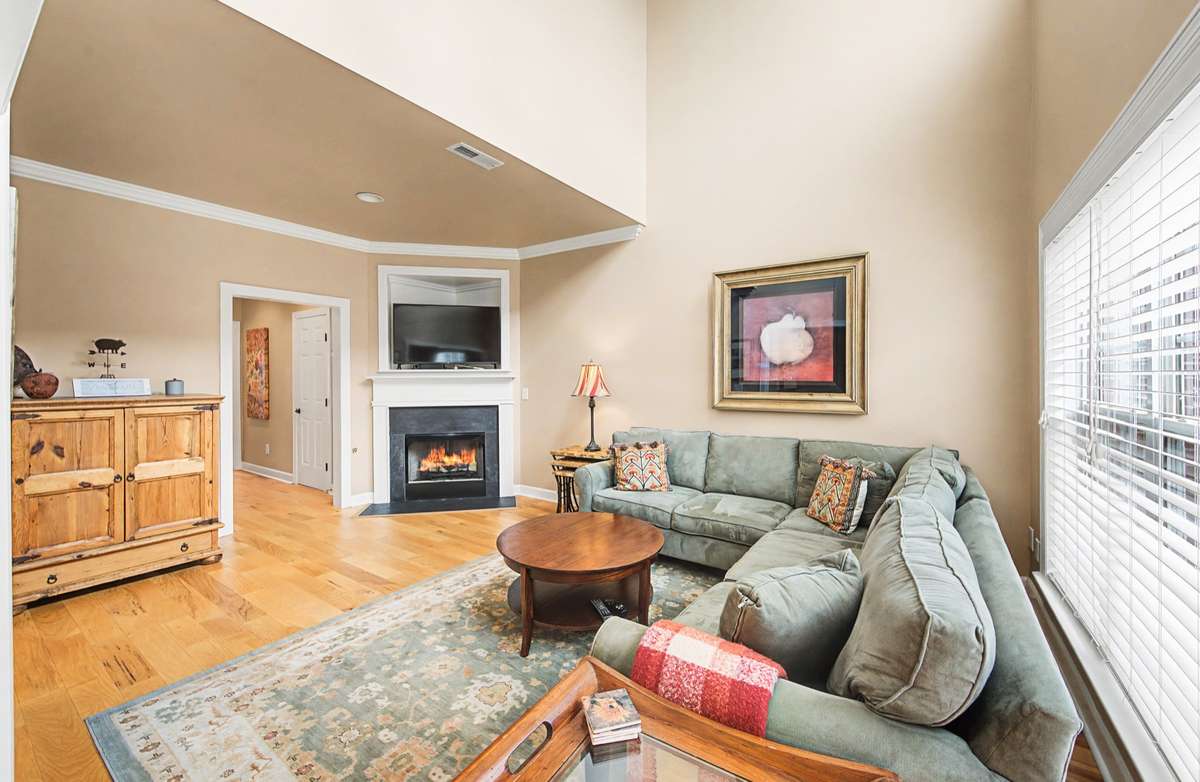 Hardwood floors, elegant crown molding, and the open layout make this space perfect for relaxing or entertaining. The spacious seating area comfortably accommodates gatherings while maintaining a warm, welcoming feel
