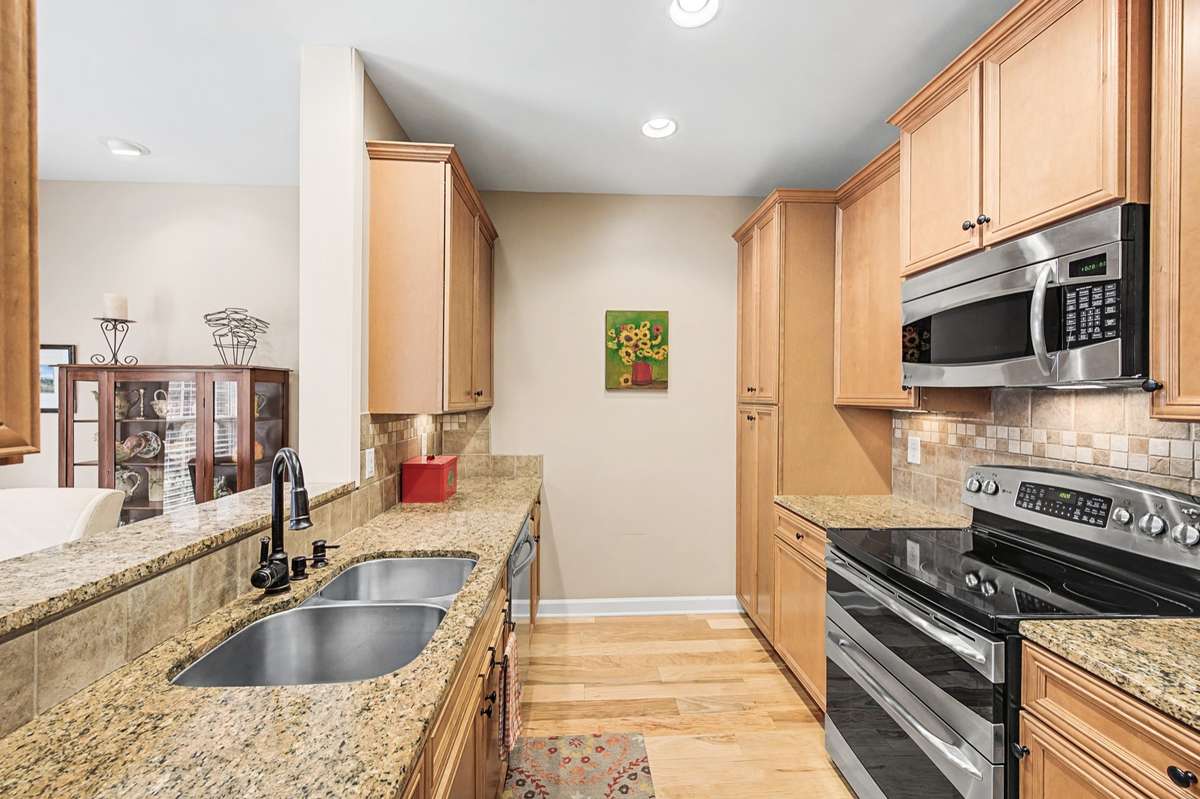 This kitchen makes the most of the space with ample granite countertop space for food prep, and a pass through is a great option for addition seating.  Naturally stained wood cabinets including a pantry which provides plenty of storage space.