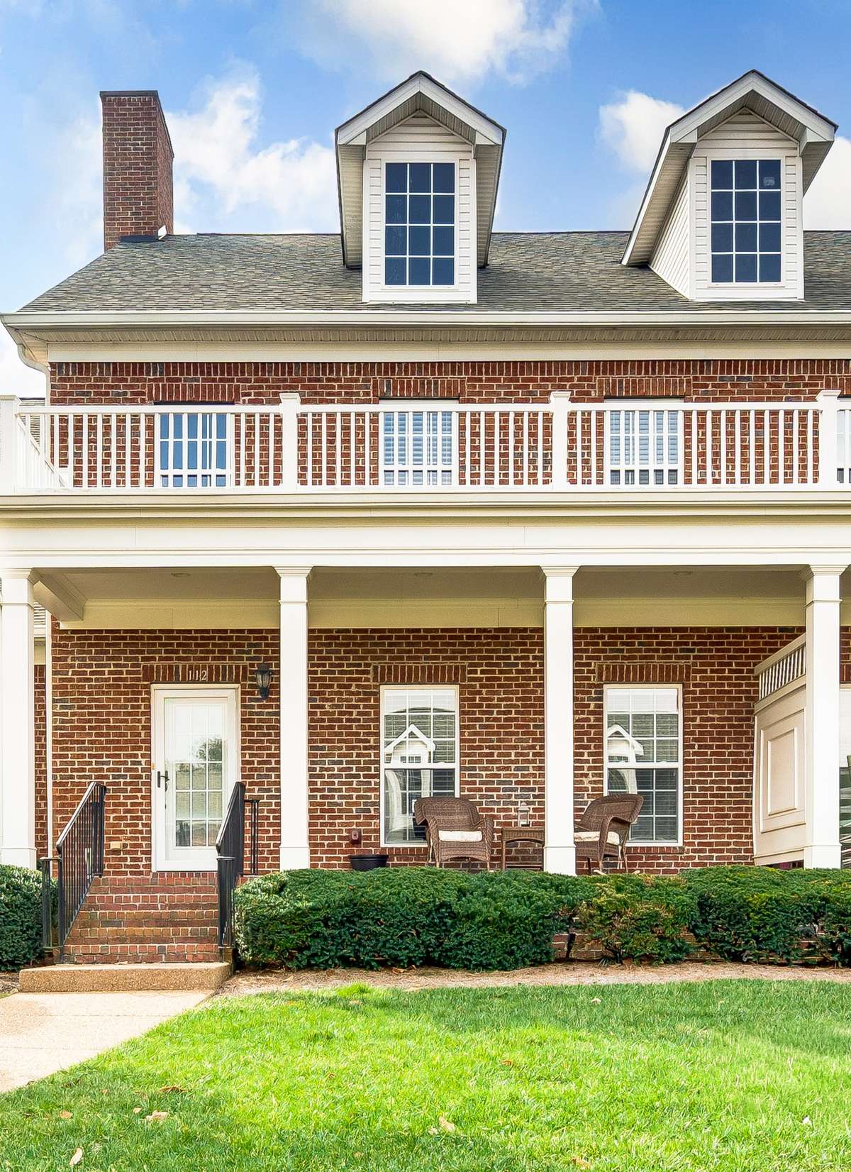 Charming brick townhome features classic architecture and inviting outdoor living spaces.  The welcoming front porch is perfect for relaxing with morning coffee.