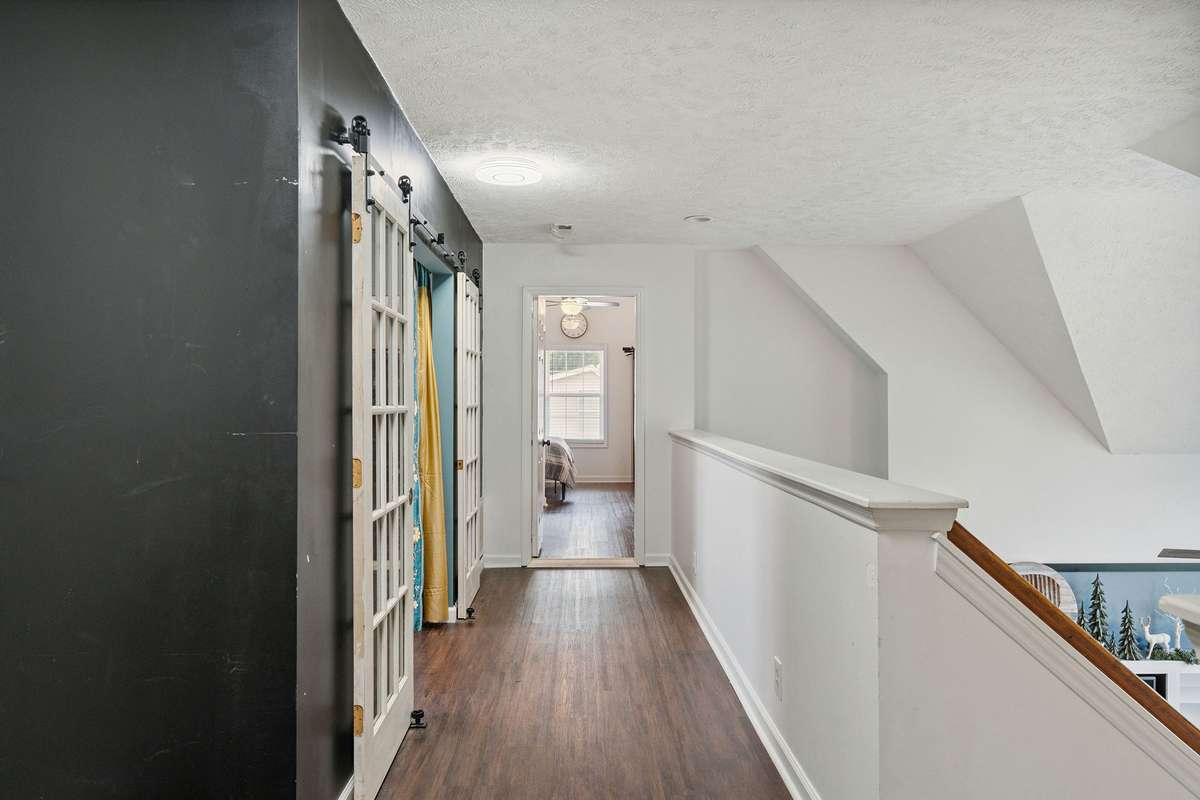 Upstairs hallway open to the downstairs in this 4 bedroom, 3 and a half bathroom in Murfreesboro Tennessee with over half an acre of land and no HOA, a two car garage and updated kitchen.