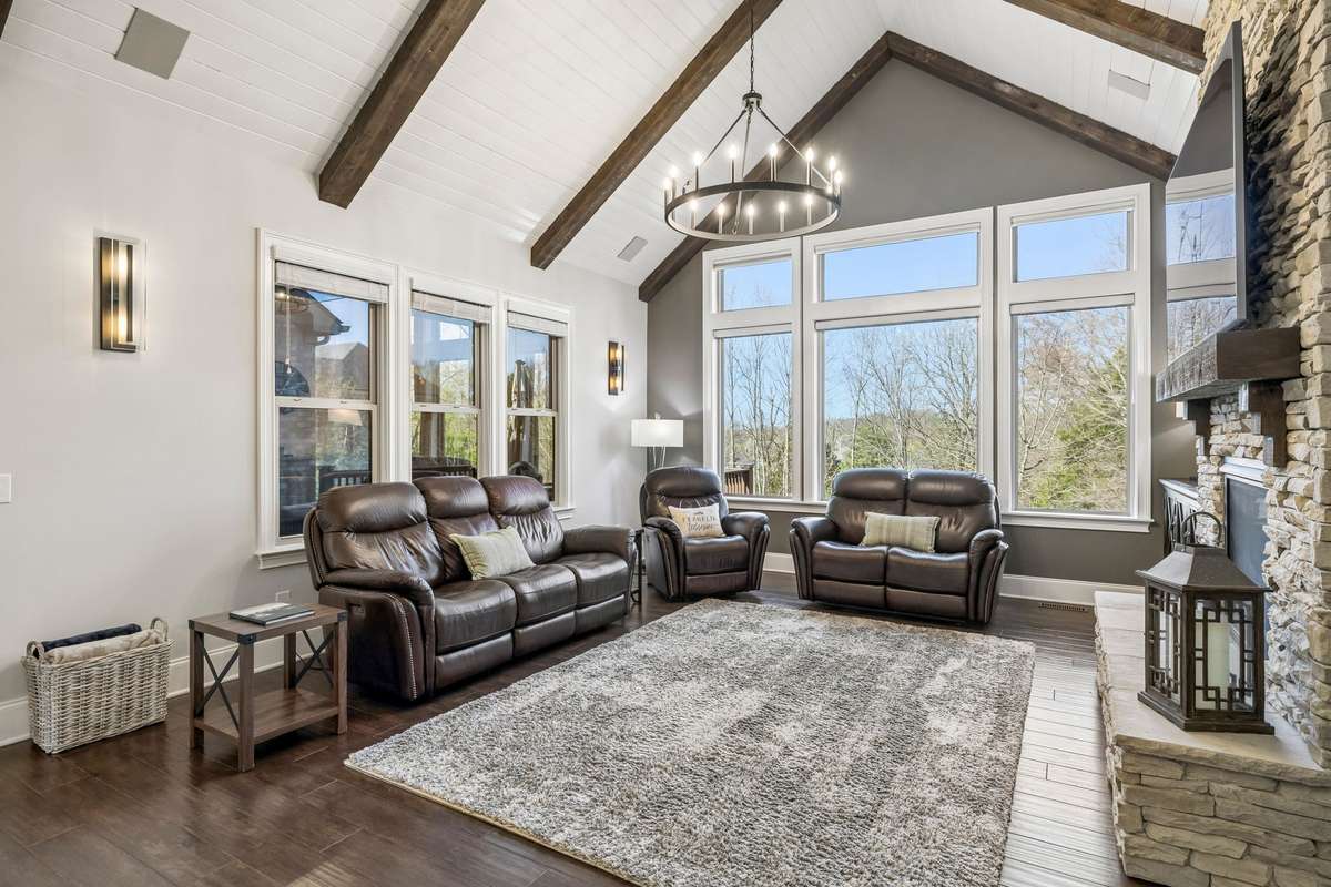 The wall of windows in the Den are tinted and have convenient mechanical shades on the top row and Duolite Silhouette Blinds on the bottom row. The wall sconces provide a beautiful extra touch of detail.