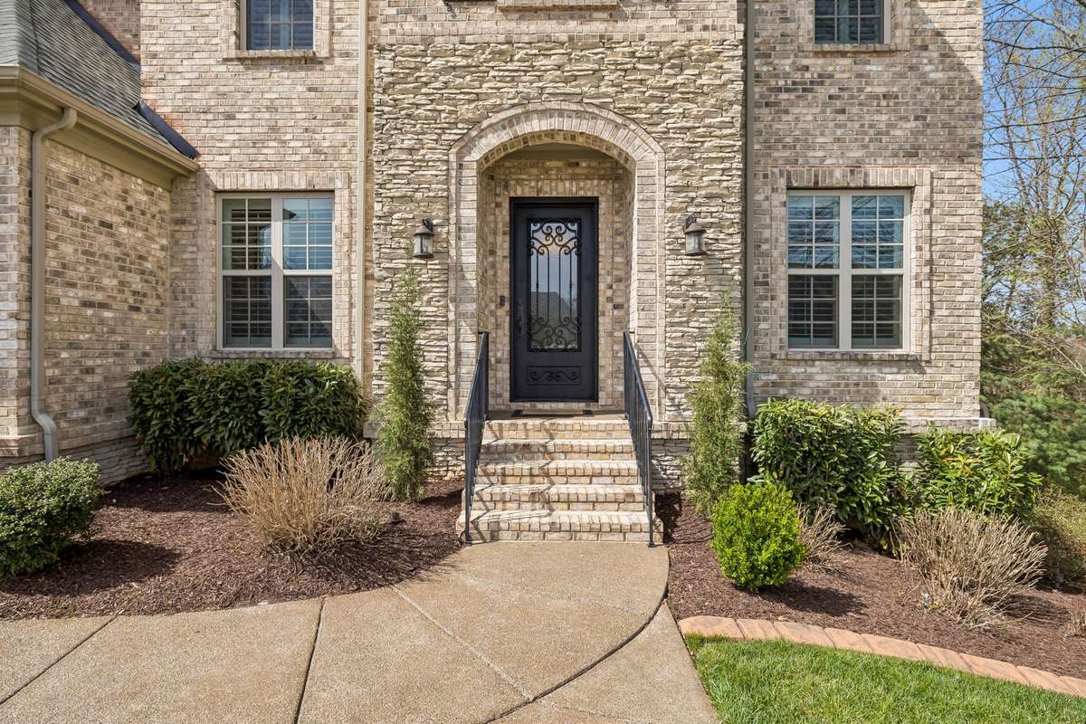 Impressive entry featuring a stacked stone facade and an iron Lion entry door that has been refinished.