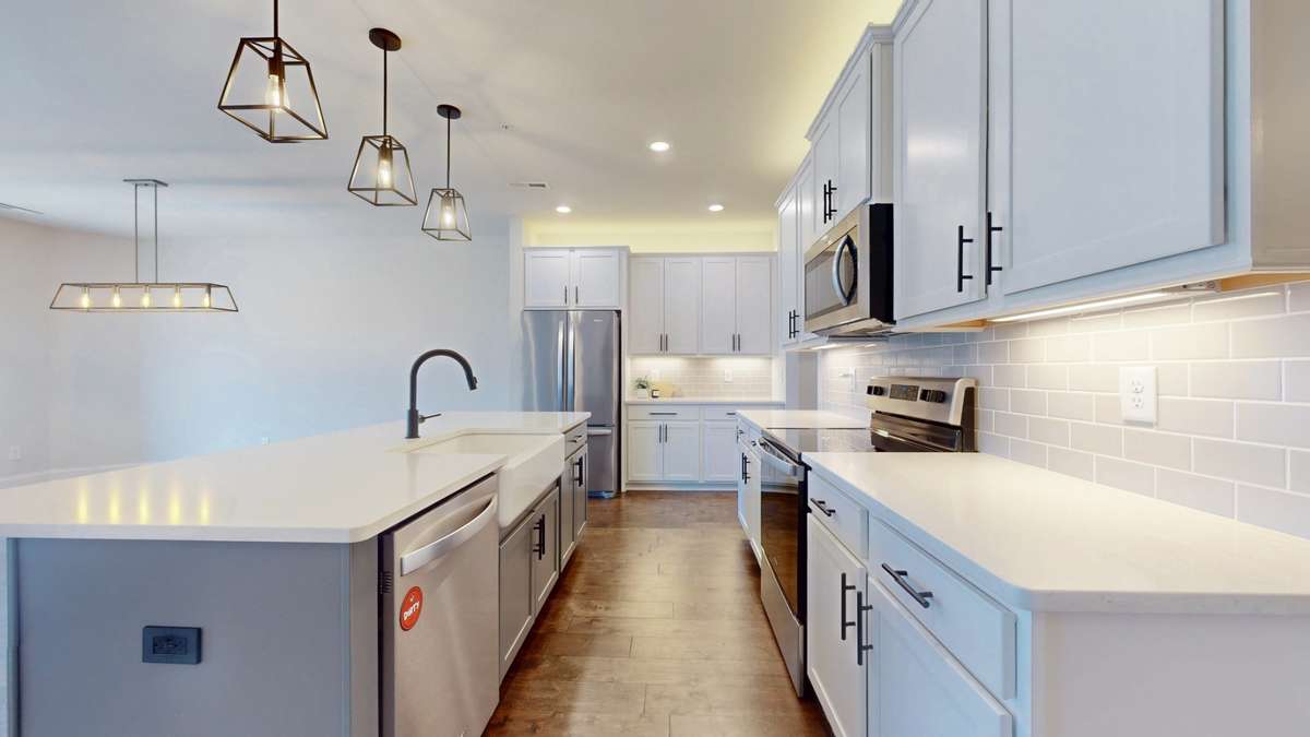 Every detail has been elevated in the kitchen, including quartz countertops, stainless steel appliances, premium cabinetry with sleek black hardware, and custom cabinetry lighting.