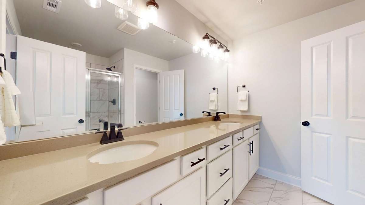 Primary suite with dual vanities and large shower.