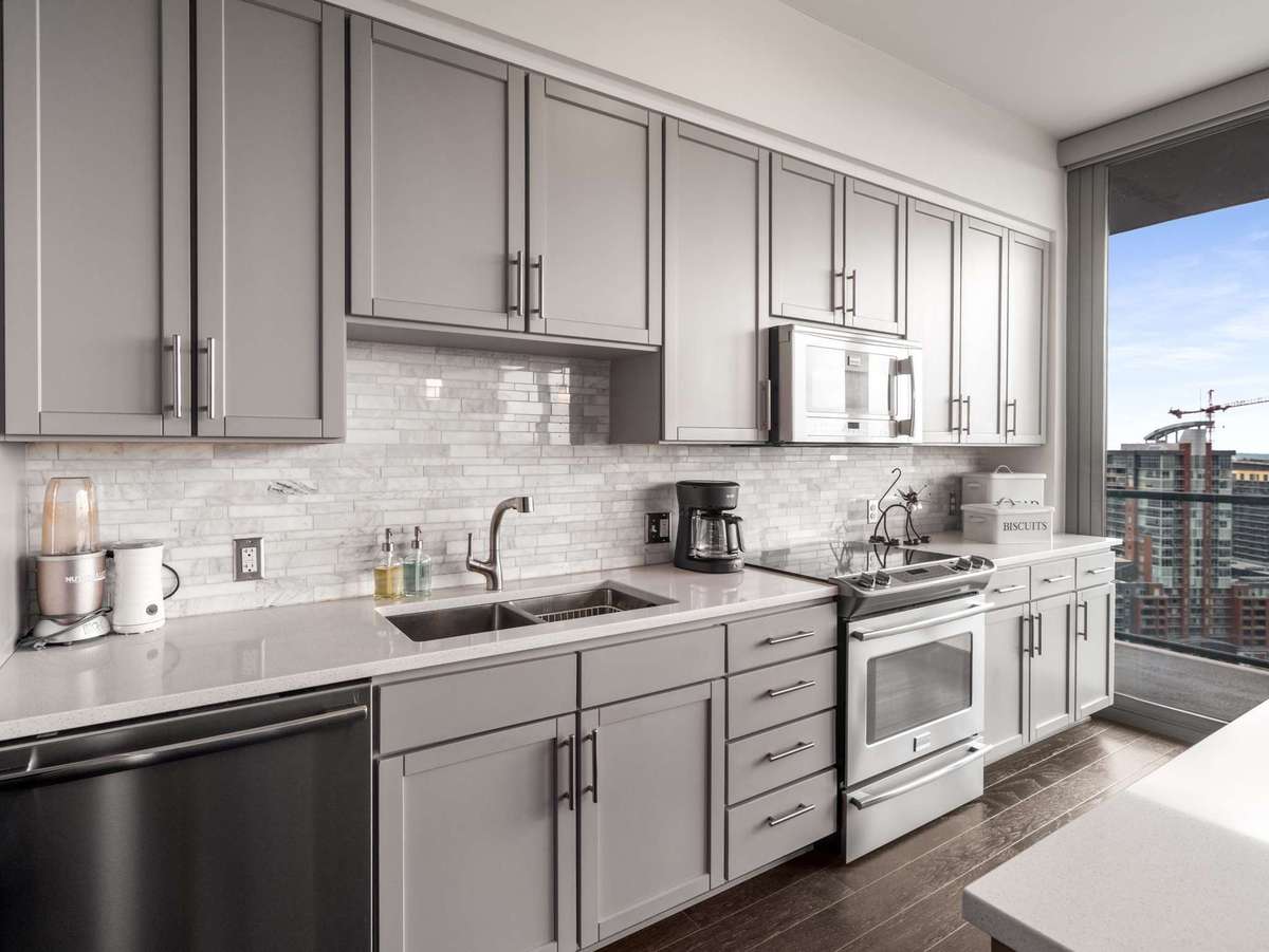 Galley styled kitchen has wall of cabinet space including separate pantry with large eat in island.