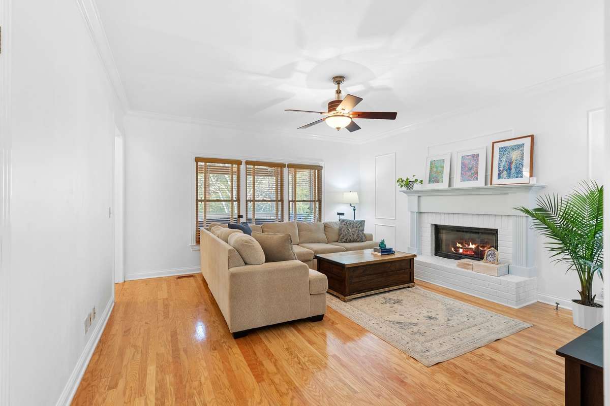 Down the hall just has the office space is the living room area, featuring the gas fireplace, ceiling fan, 3 windows looking out into the screened-in back porch.