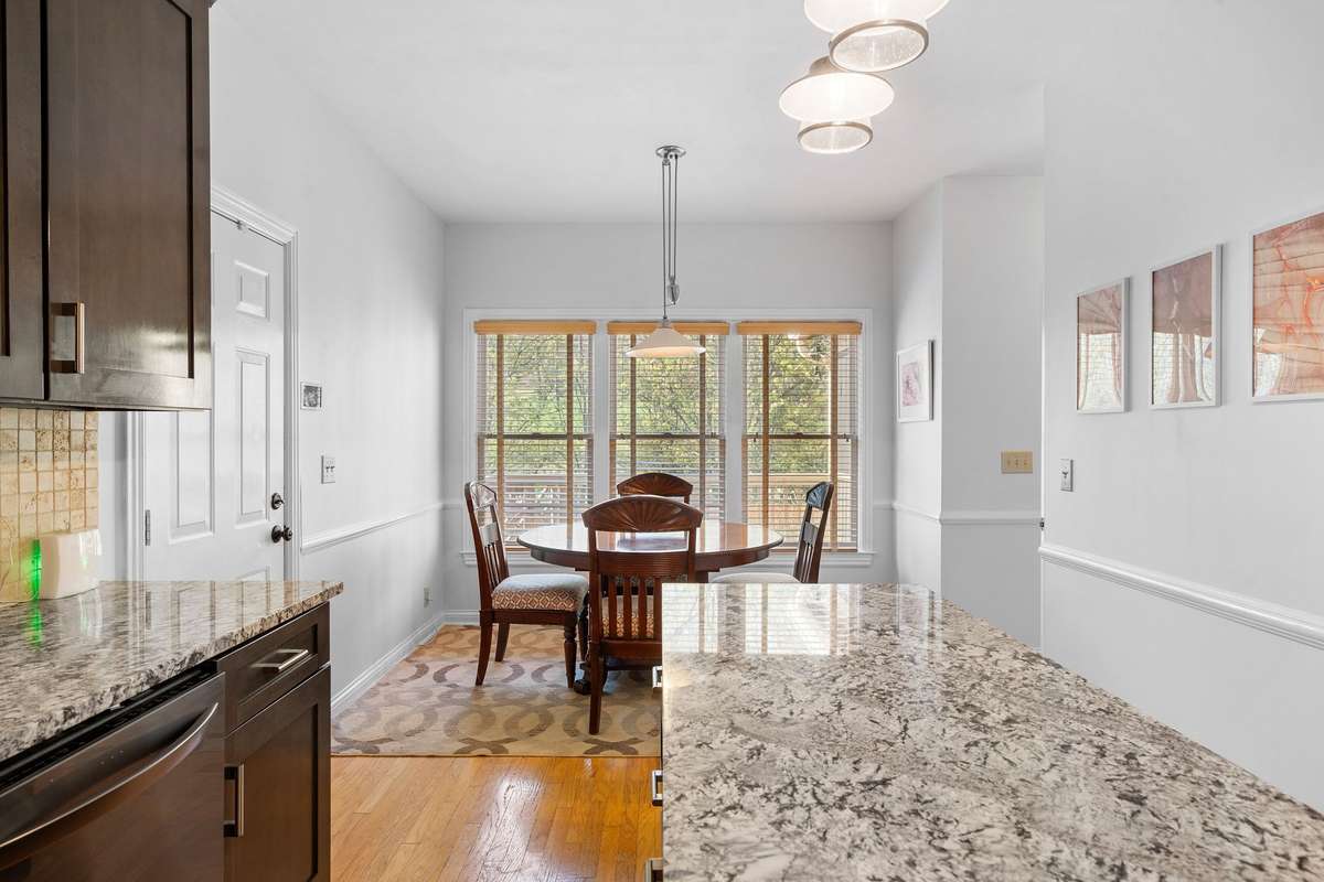 View of the eat-in dining space with 3 large windows to enjoy the view of the beautiful backyard and screened-in back porch.