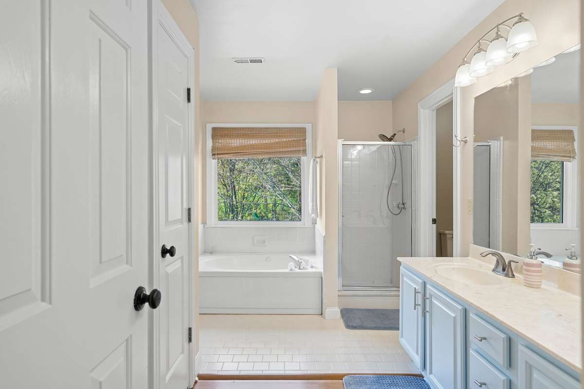 The door to the far right in the primary bathroom leads to the walk-in closet and the door on the left in front of the sinks is a linen closet.