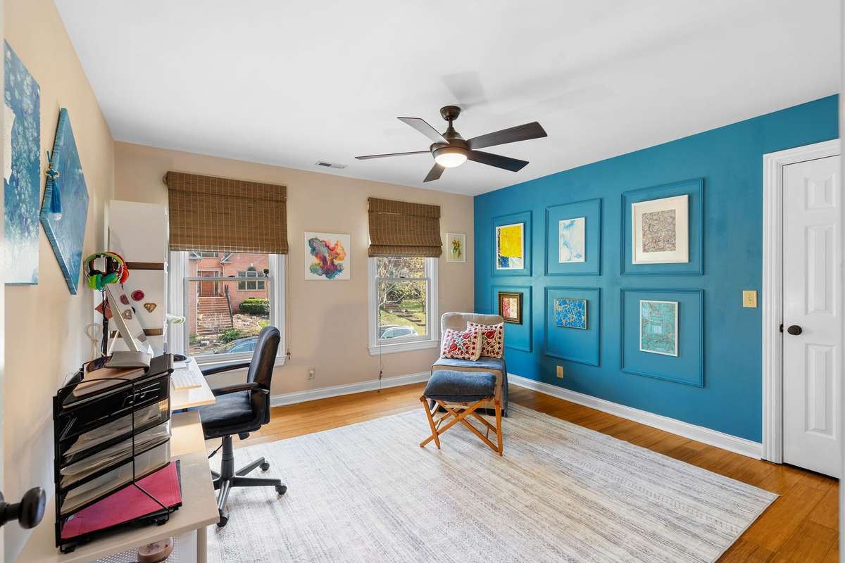 Bedroom #2 sits in the middle of the home and faces the front of the home. The sellers have painted an accent wall in since they use this room as a creative art space.