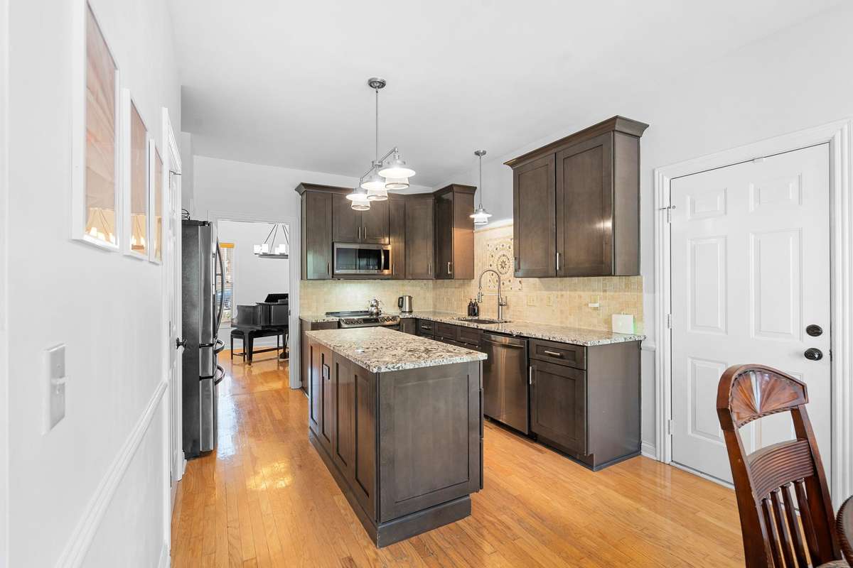 This kitchen has 2 pantries, one of which is a walk-in + an eat-in dining space!! The door to the right leads to the 2 car garage.