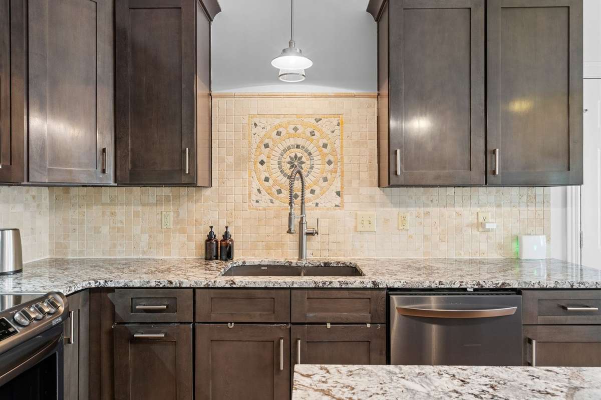 Kitchen tile back splash and decorative design above the sink.