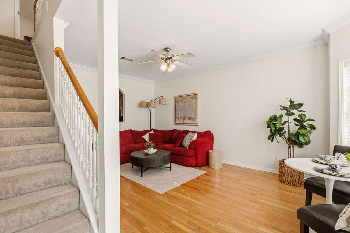 Walk into an open living and dining area with hardwood floors and fresh paint.