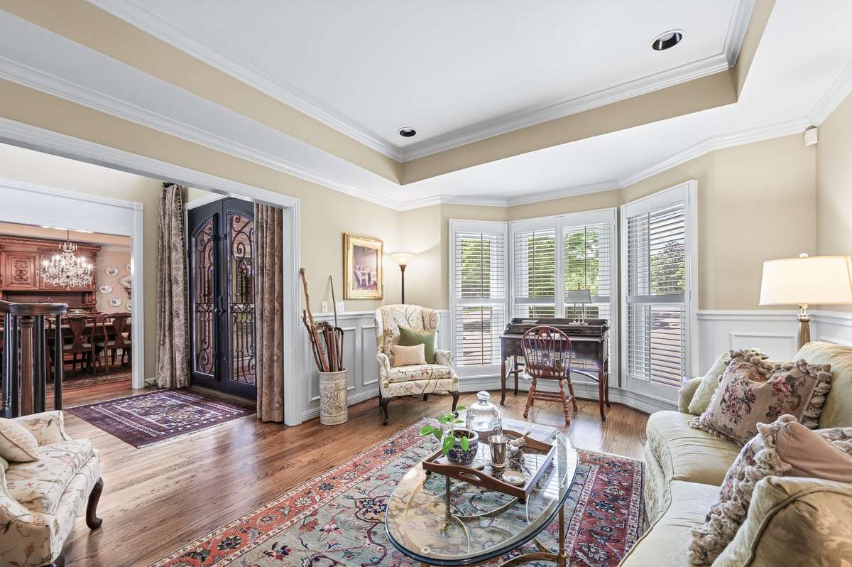 Formal sitting room with bay window & hardwood flooring.