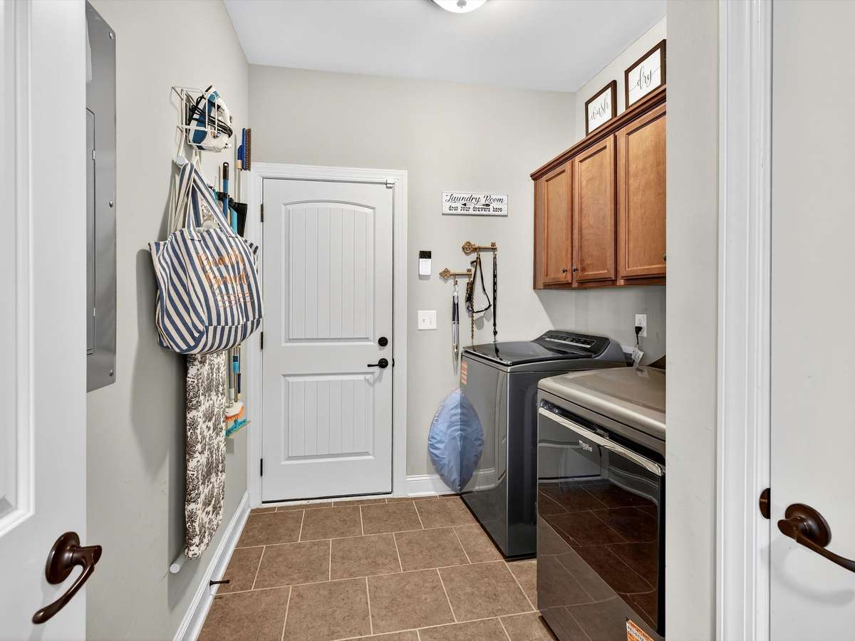 Utility/mud room with closet and cabinet storage.  Located between garage and living room