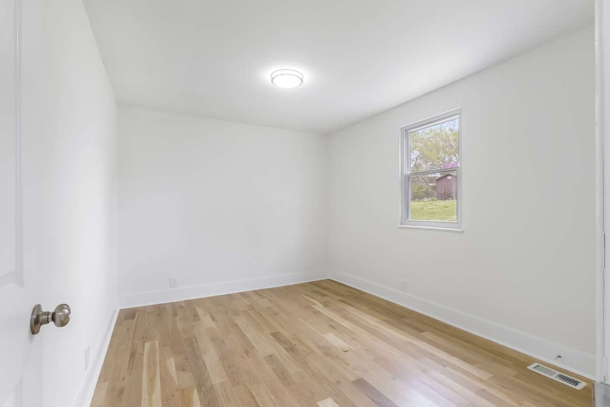 Another bedroom with bright windows and neutral finishes.