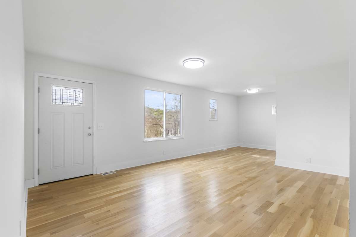 Looking from the living room corner near bedroom hallway toward the dining area and kitchen