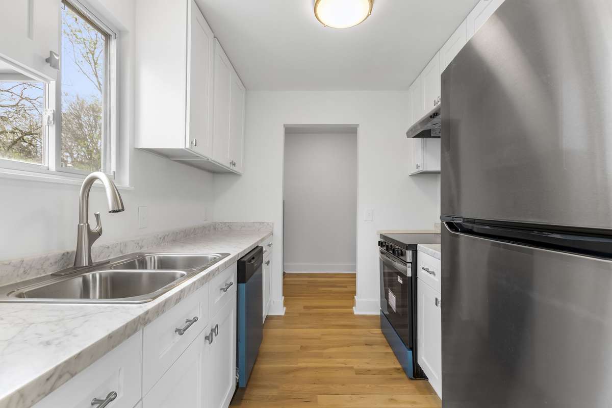 Another view of the kitchen with stainless steel appliances and updated finishes.
