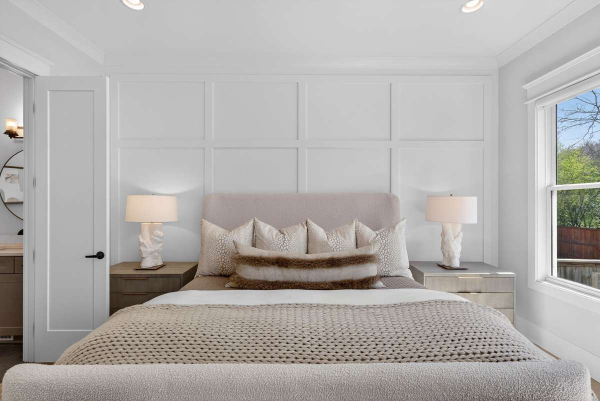 A serene primary bedroom highlighted by custom wall detailing.